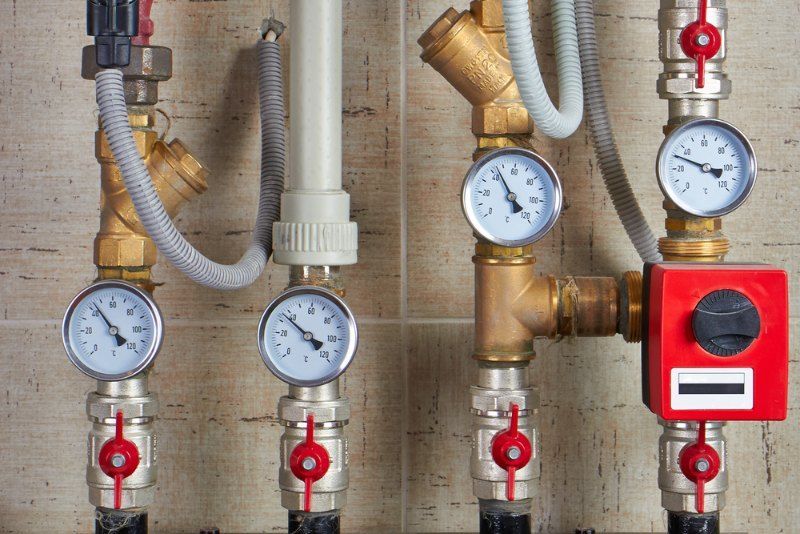 Plumbing Pipes With Gauges, Valves, and a Red Control Box, Likely for a Heating System — Tony Brown Plumbing & Gas Services in South Grafton, NSW
