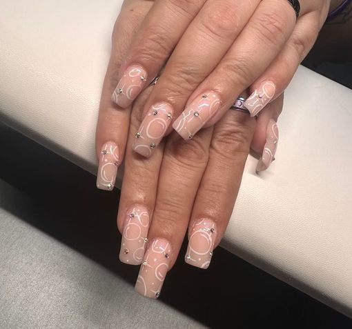 A close up of a woman 's nails with a design on them