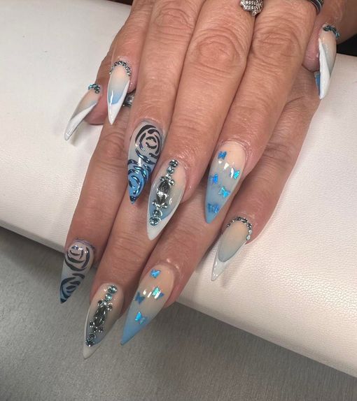 A close up of a woman 's nails with blue and white designs