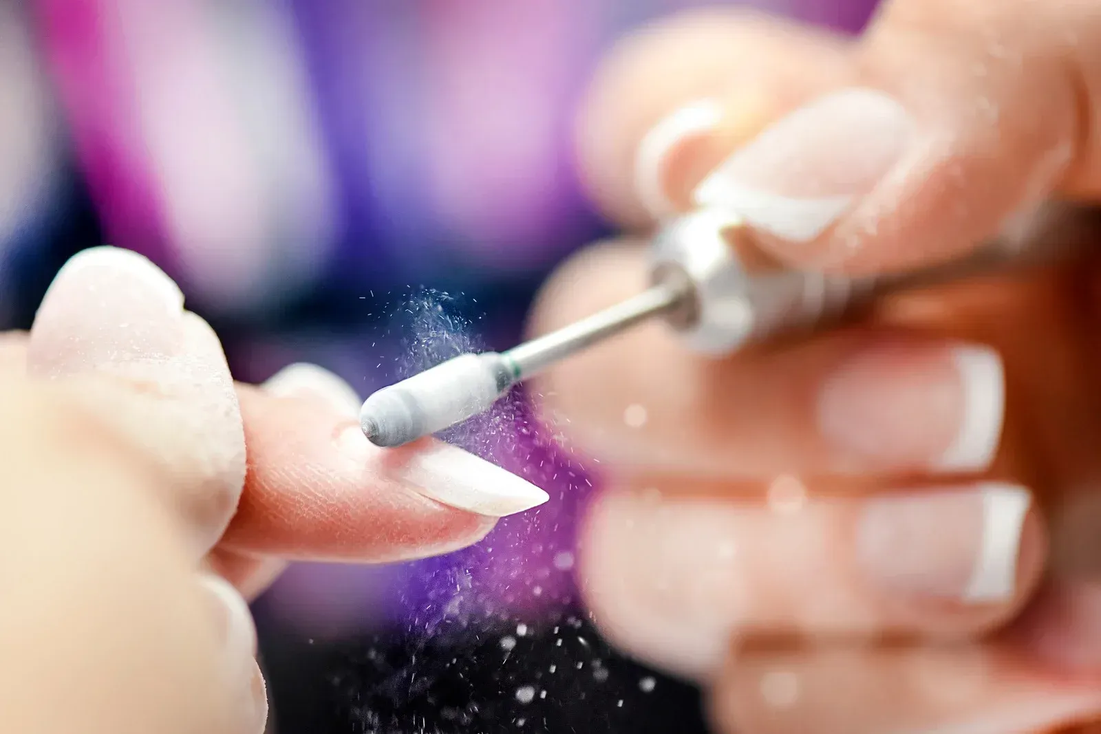 A woman is getting her nails done at a nail salon.