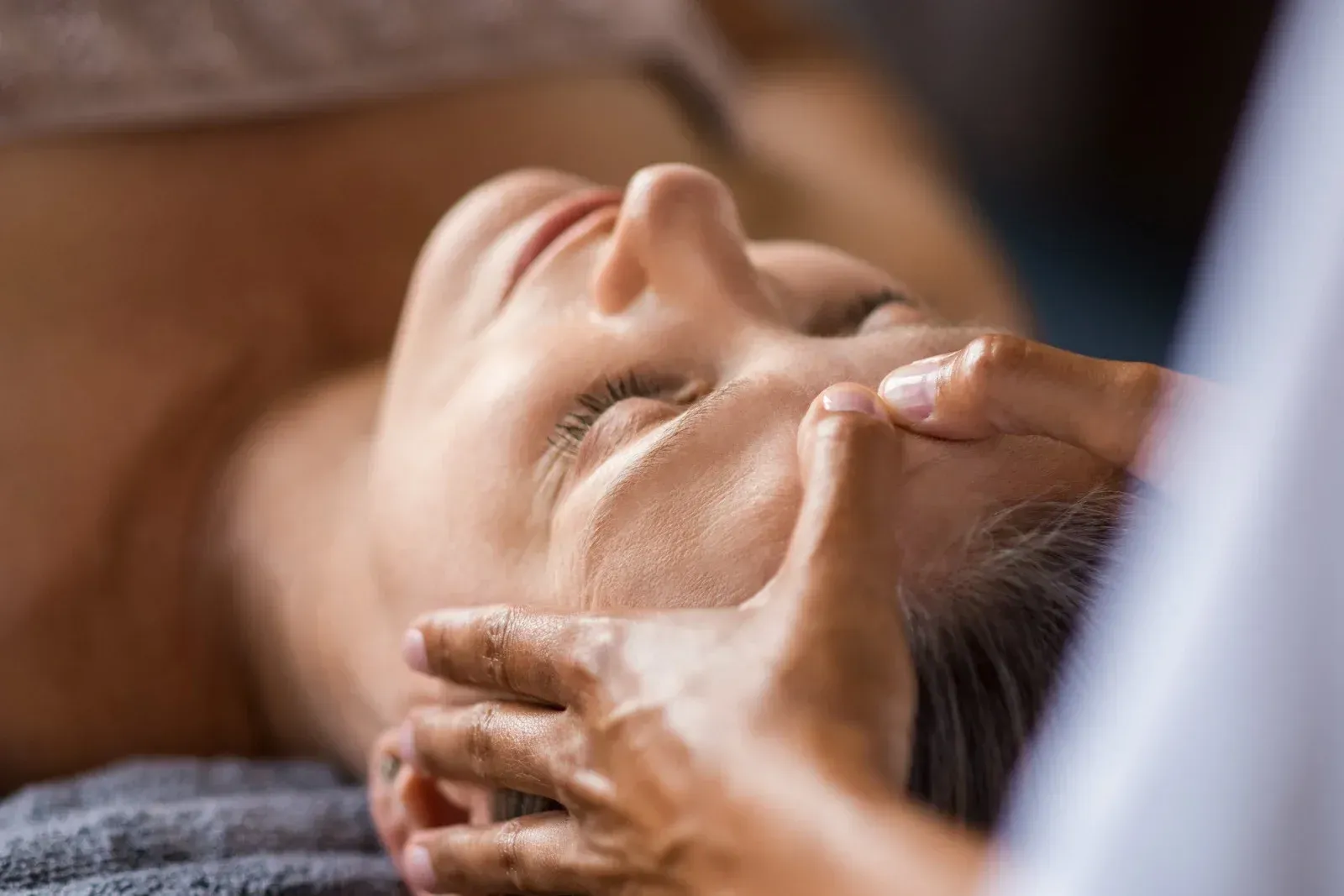 A woman is getting a head massage at a spa.