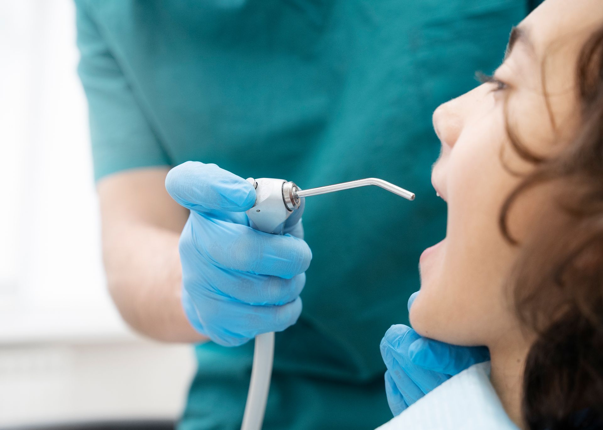 A woman is getting her teeth examined by a dentist.