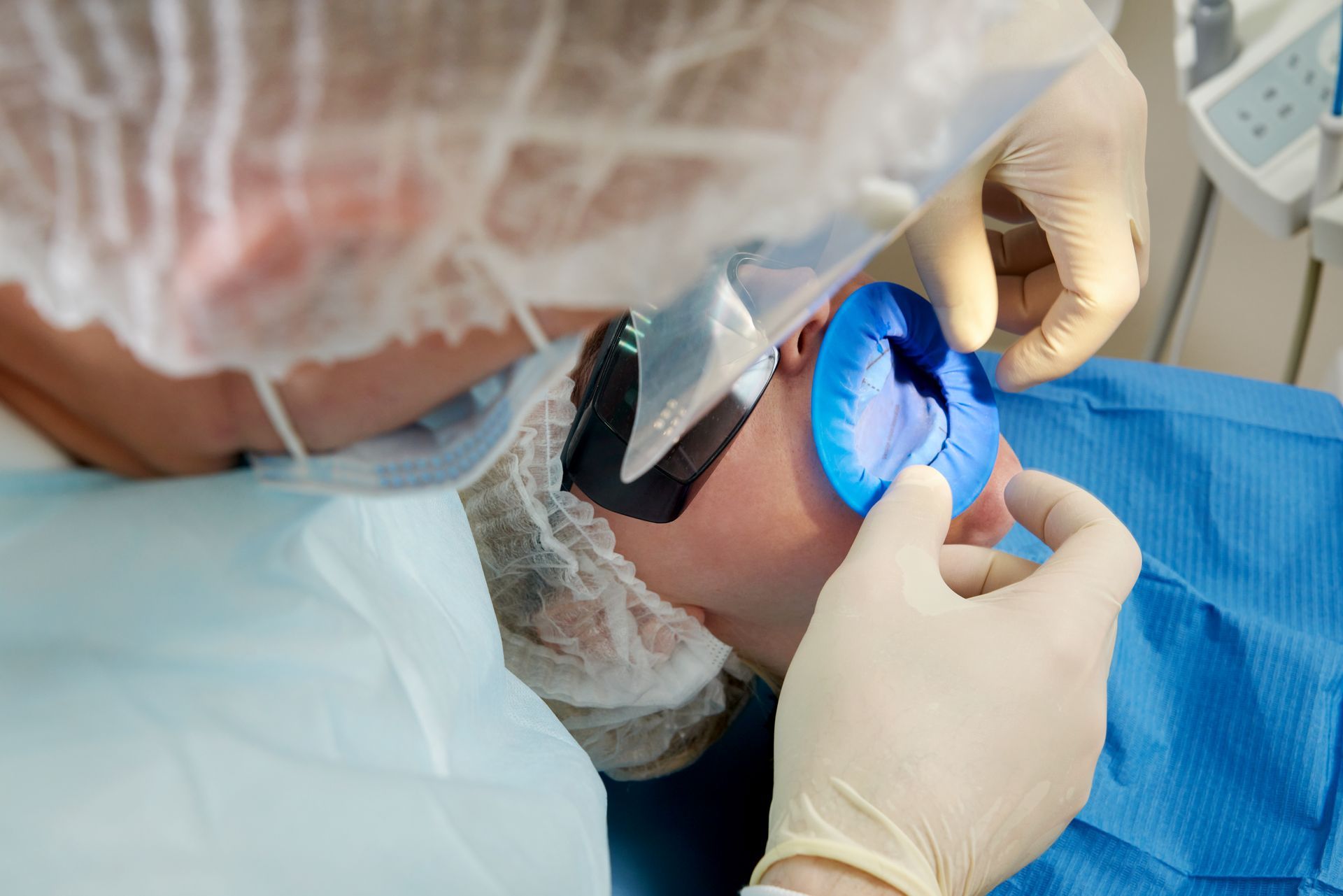 A dentist is examining a patient 's teeth in a dental office.