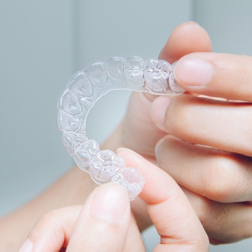 A person is holding a clear brace in their hands.