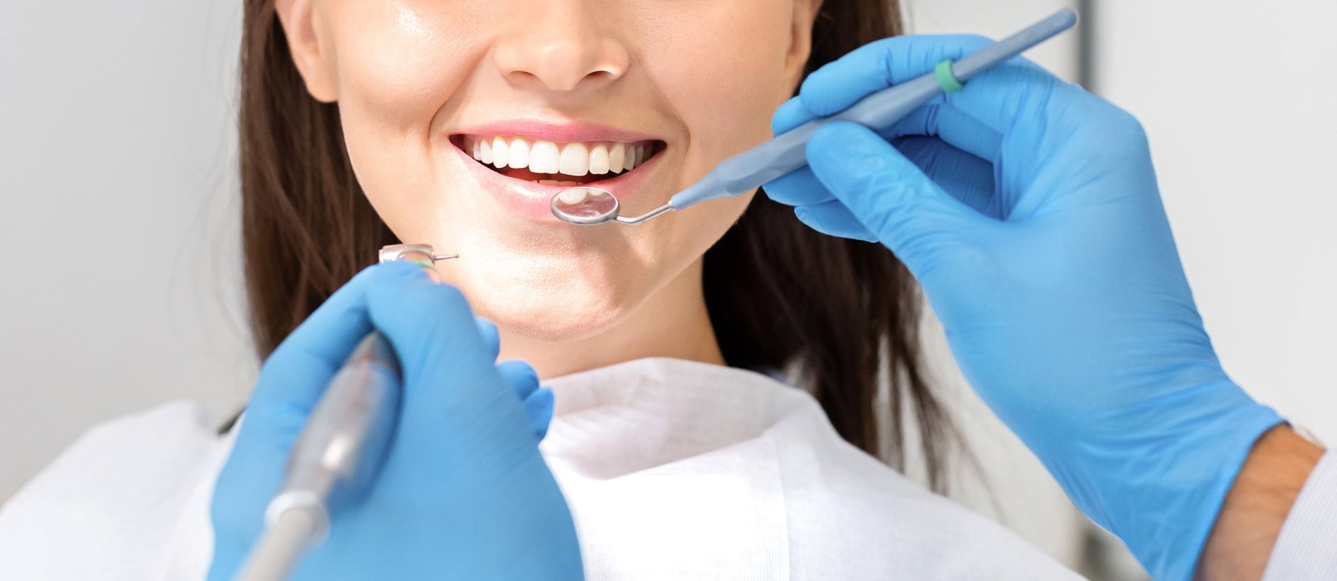 A woman is getting her teeth examined by a dentist.
