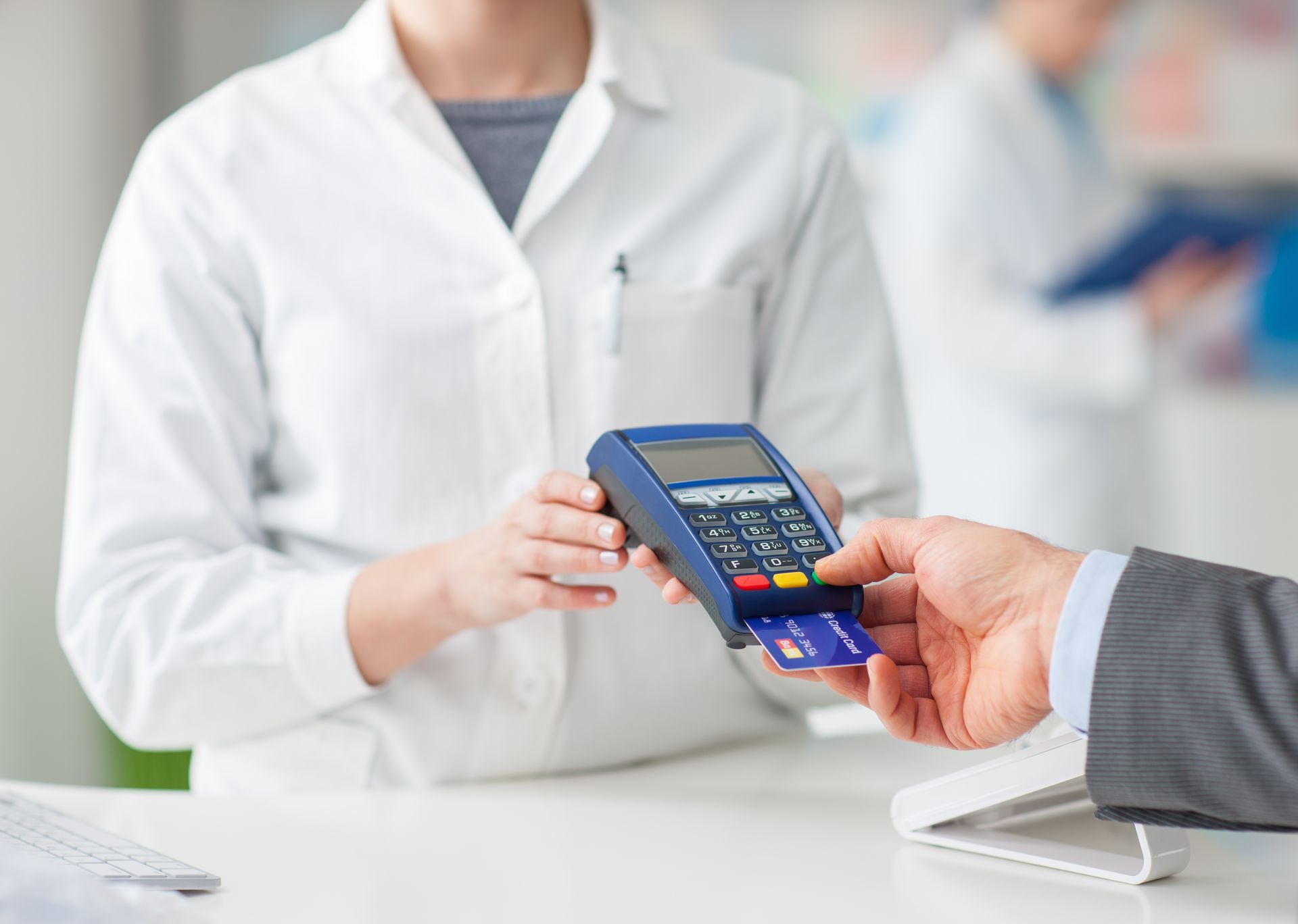A man is paying with a credit card at a pharmacy.