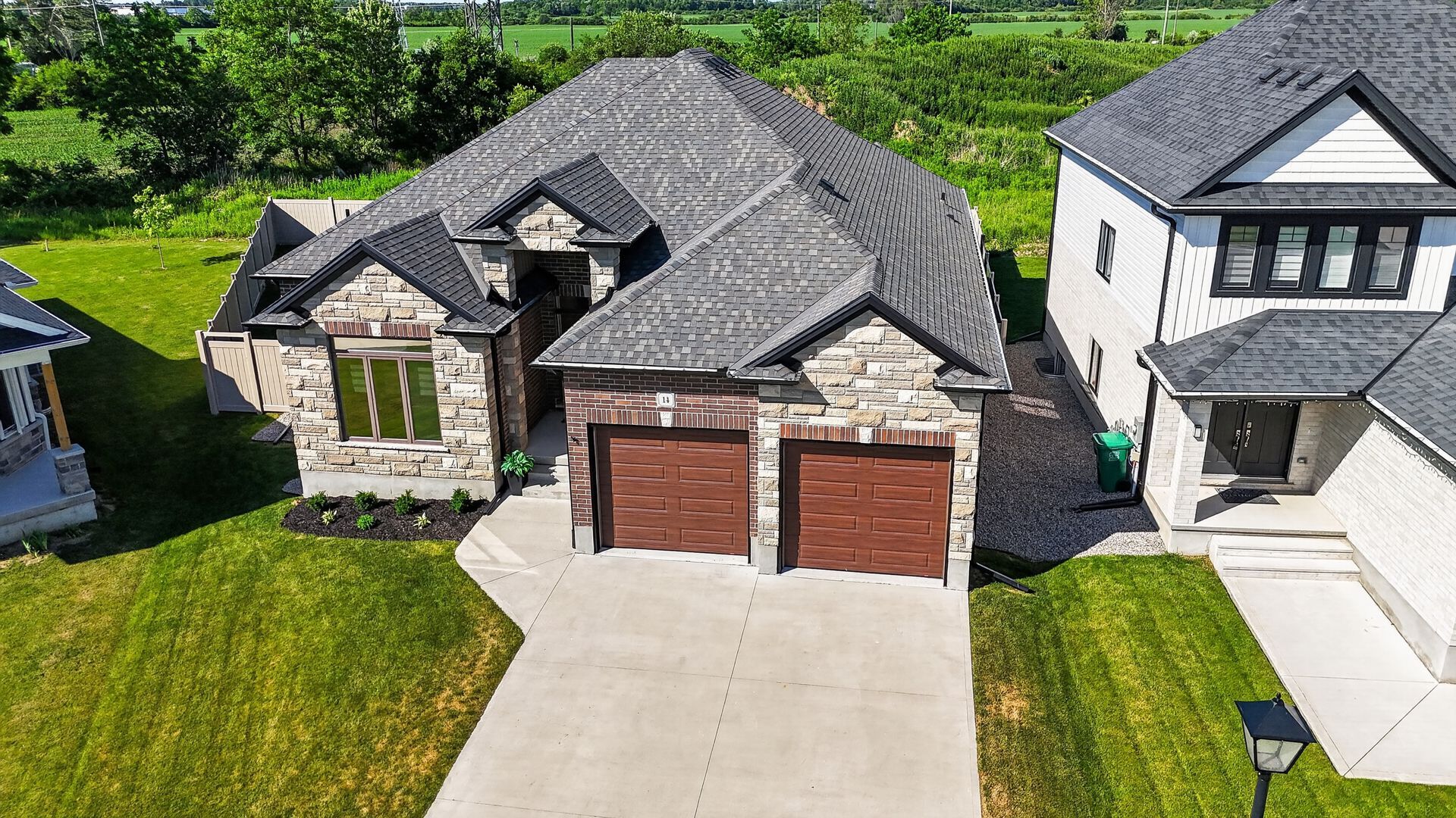 Aerial drone photo of stone and brick bungalow with double garage, Southwestern Ontario