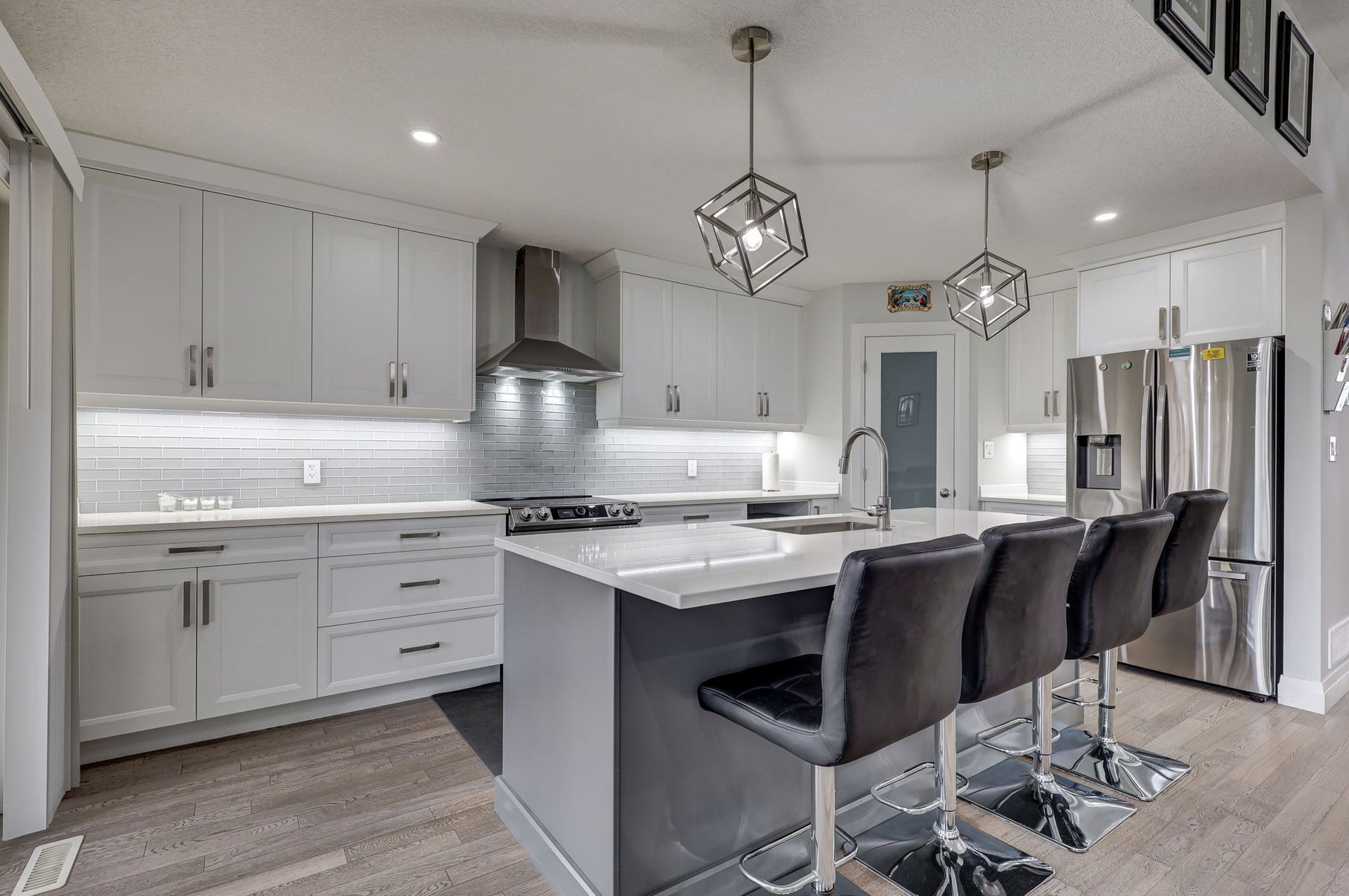 Contemporary grey kitchen with waterfall island and stainless steel appliances