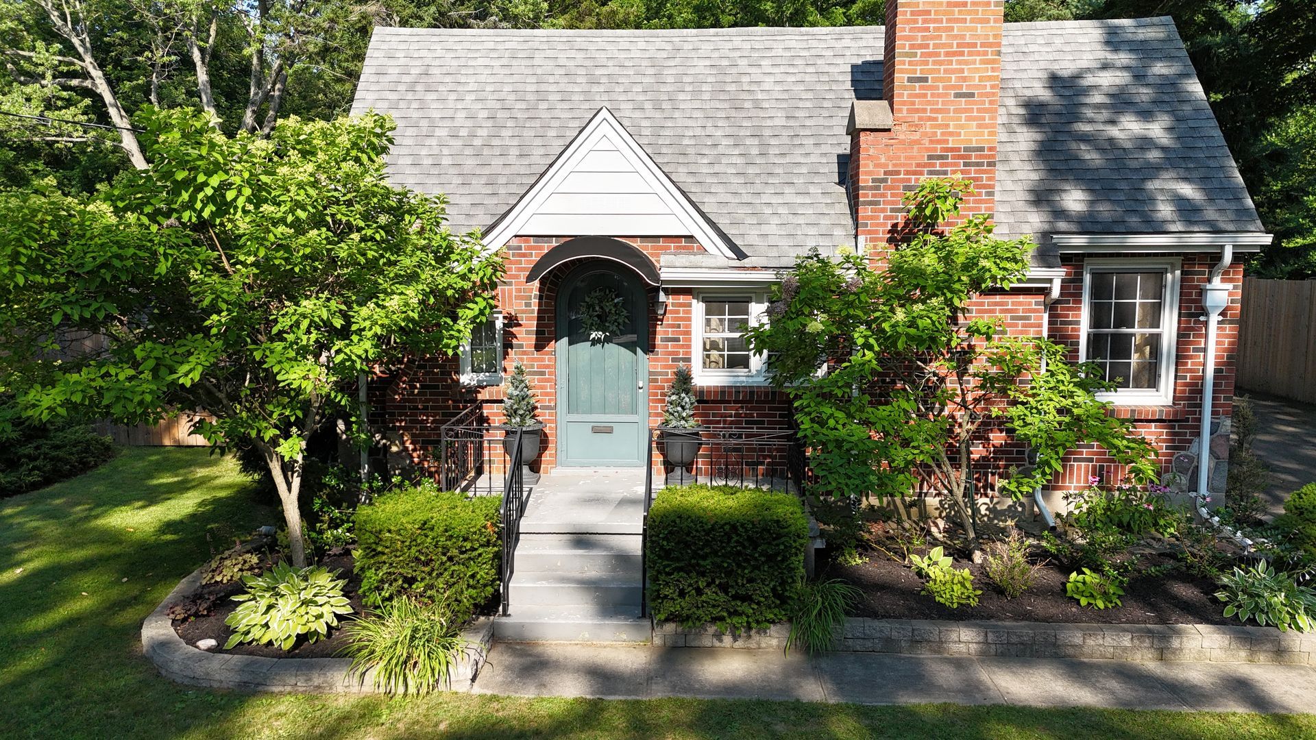 Brick cottage front entrance with arched doorway and garden