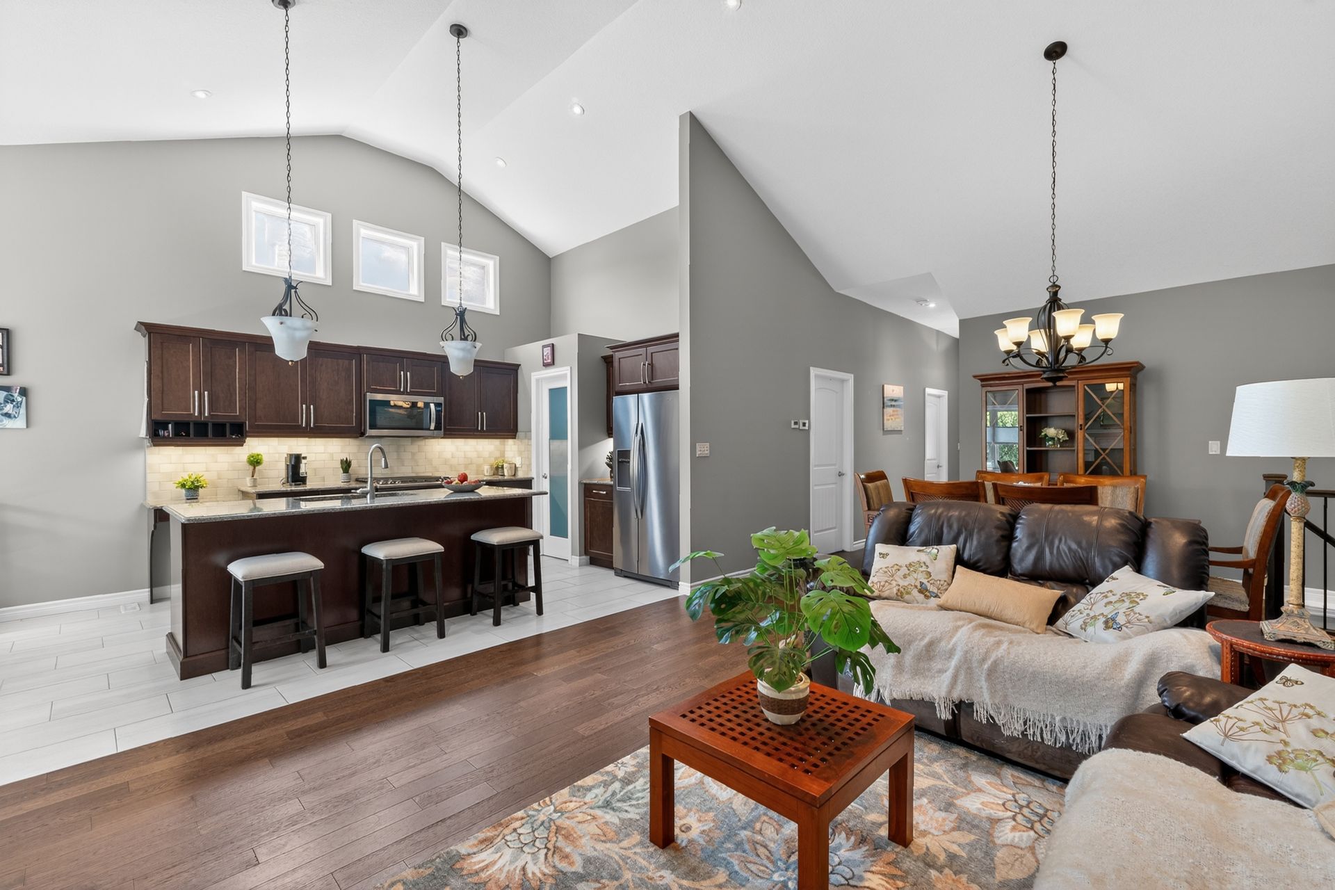Open-concept living room and kitchen with vaulted ceiling and island