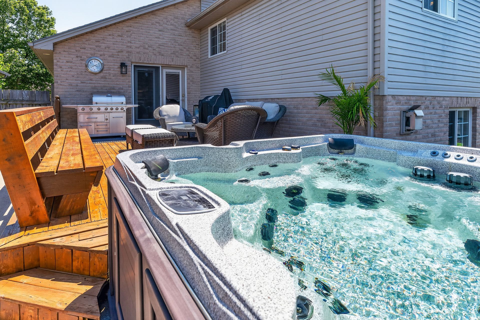 Backyard deck with hot tub, barbecue and patio furniture