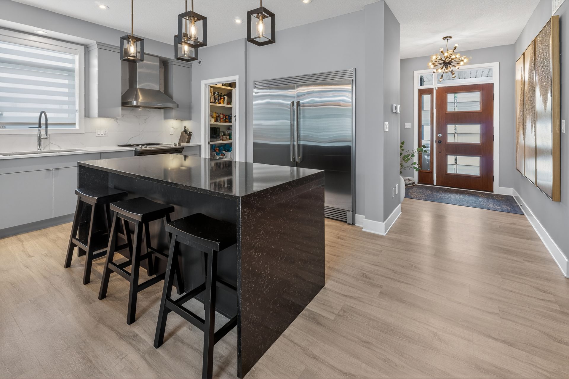 Contemporary grey kitchen with waterfall island and stainless steel appliances