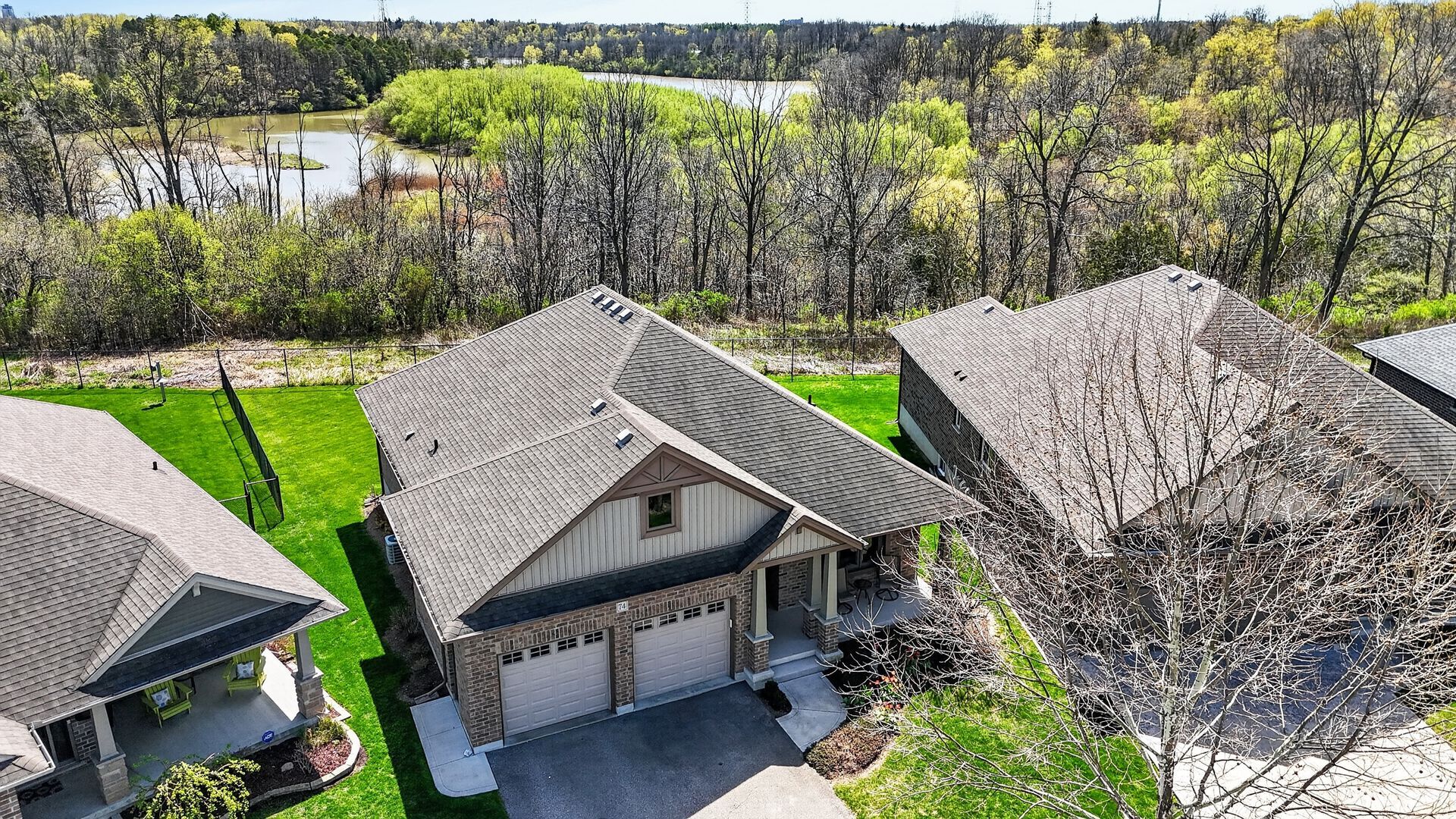 Aerial drone photograph of residential rooftops surrounded by mature trees