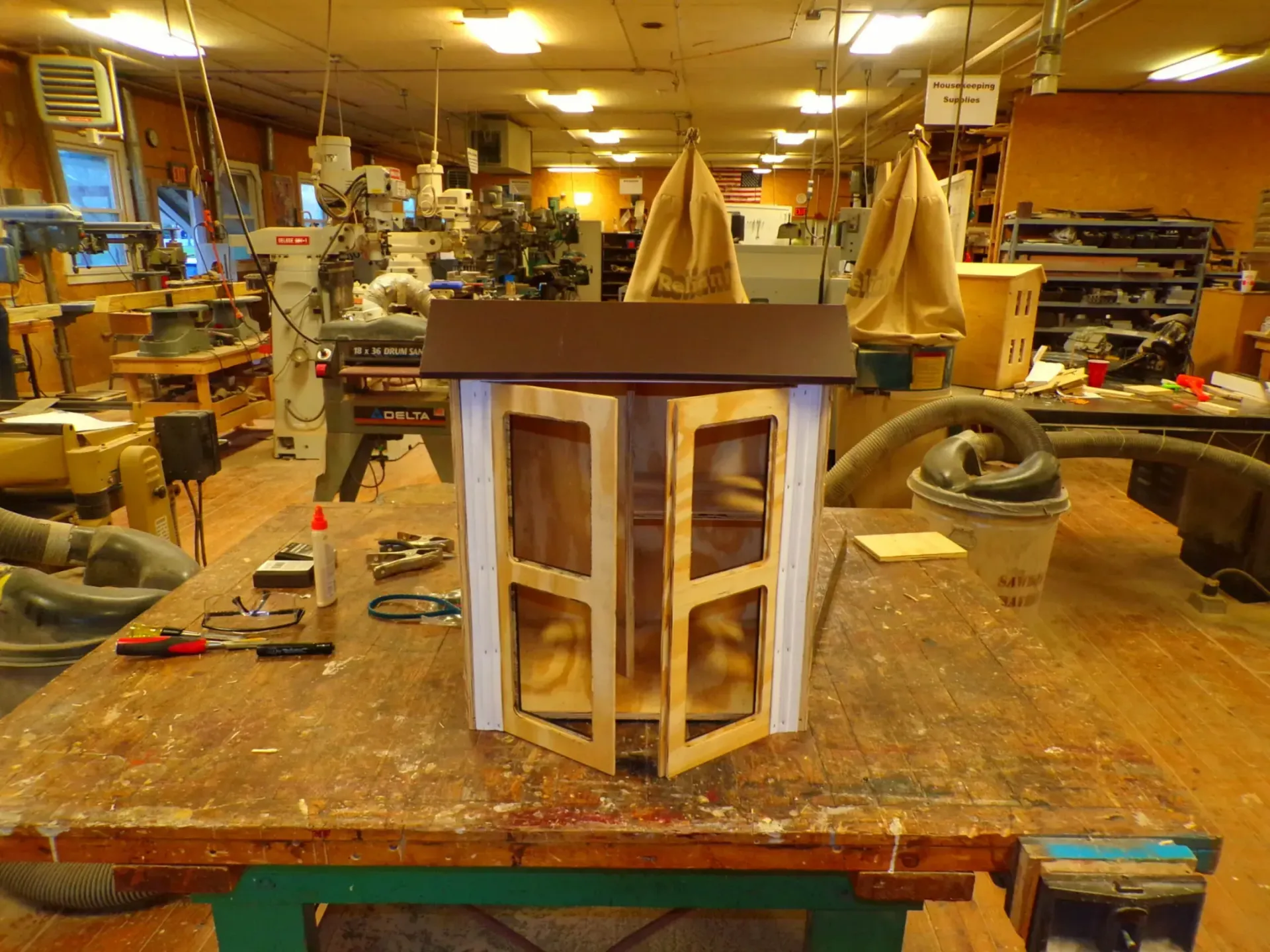 a small wooden library is sitting on a wooden table in a workshop