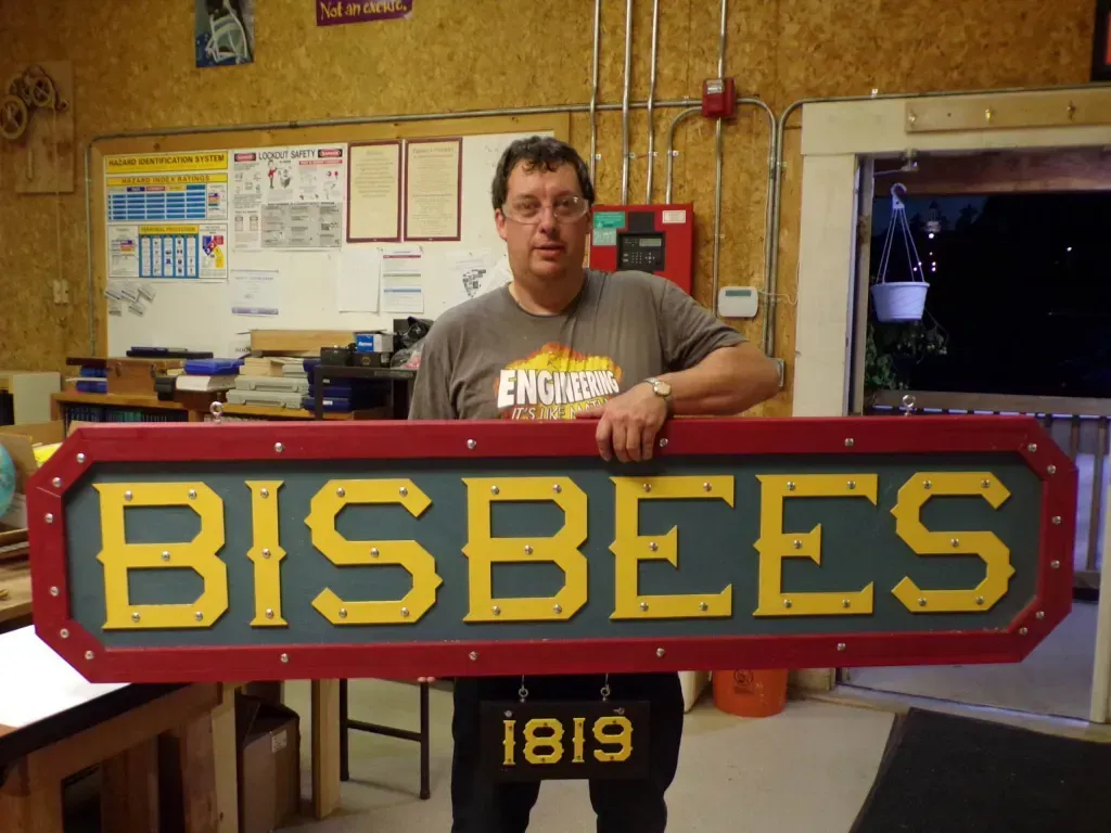 a man holding a sign that says bisbees