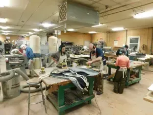 a group of people are working in a woodworking shop .