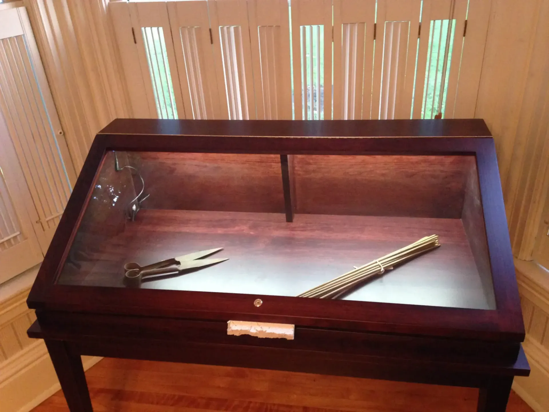 a wooden table with a glass top display case