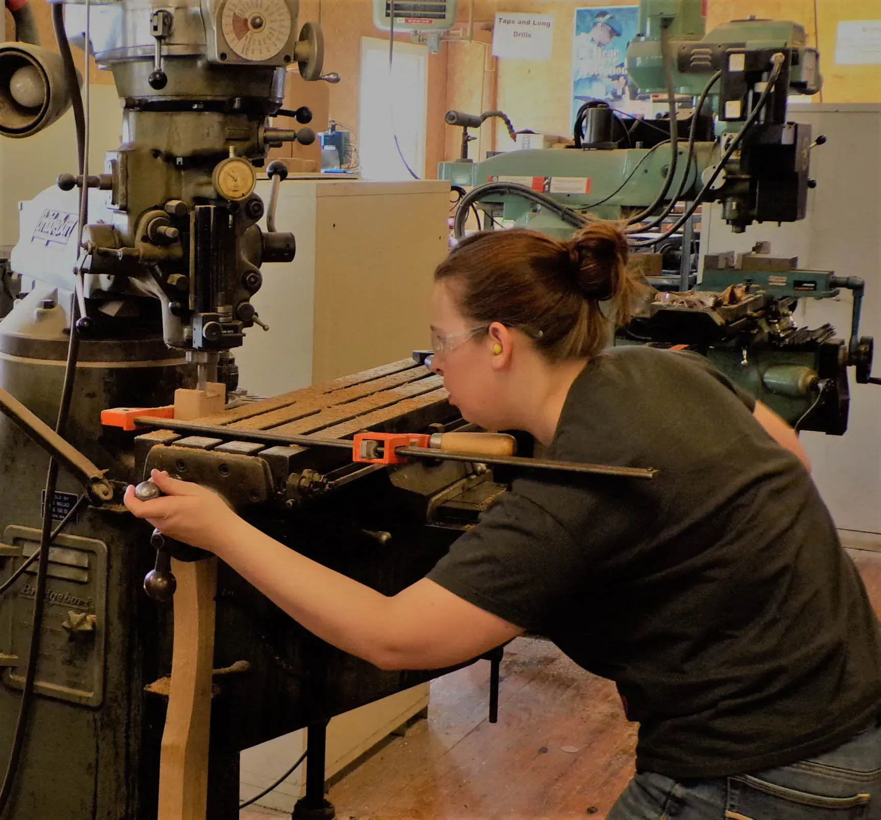 a woman in a black shirt is working on a machine