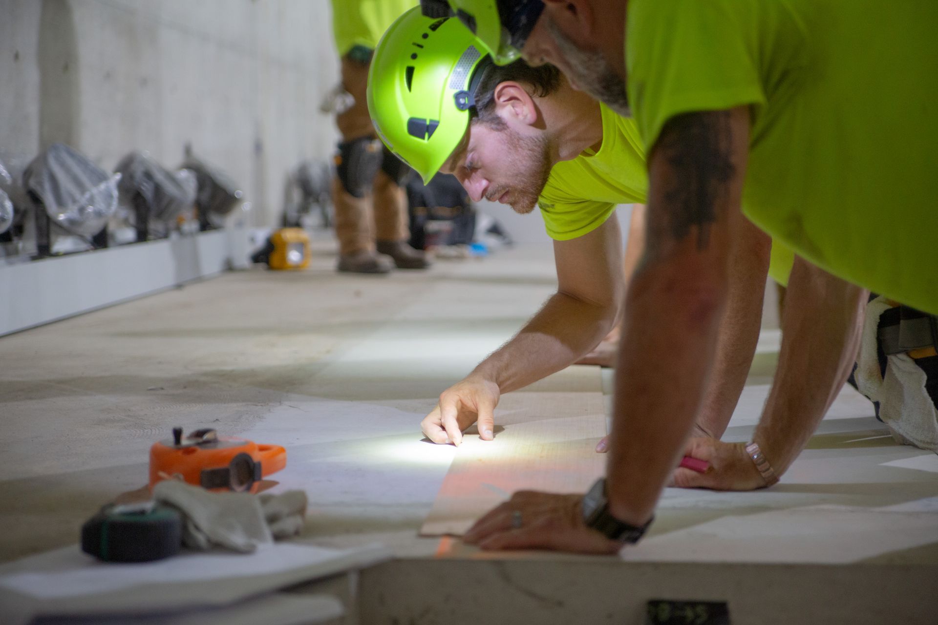 An image of KSSG on the jobsite, looking at plans and working on installation.