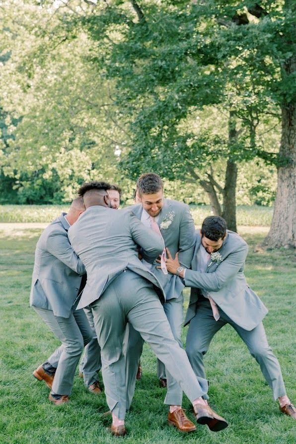 A group of men in suits are playing a game in the grass.