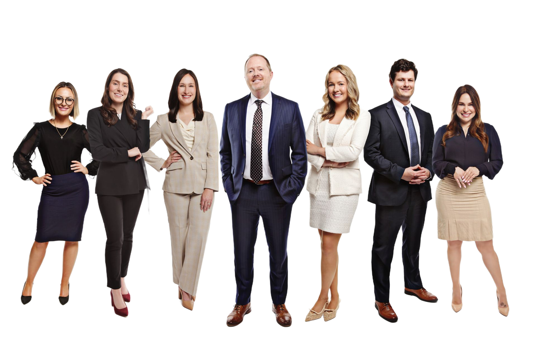 Five professionals in business attire stand together, smiling, against a white background.