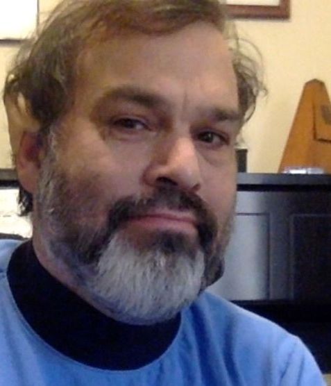A man with a beard is wearing a blue shirt