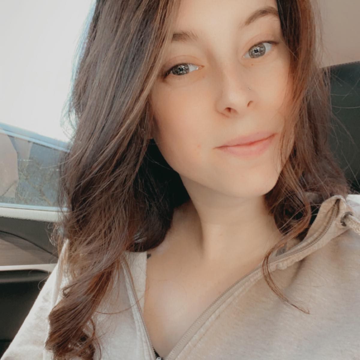 A close up of a woman 's face wearing a hoodie.