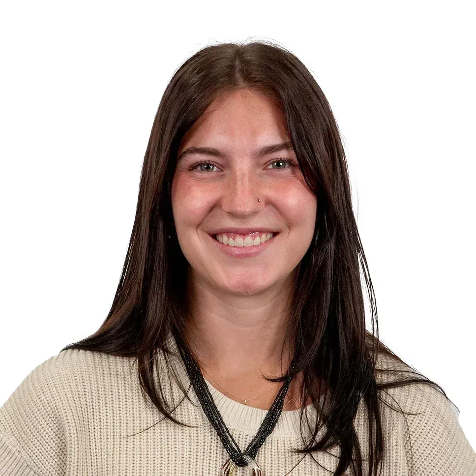 A woman with long hair and blue eyes is smiling for the camera.