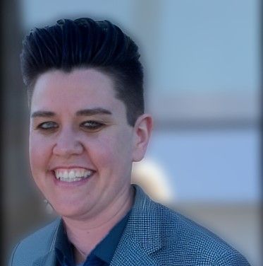 A woman in a suit is smiling for the camera