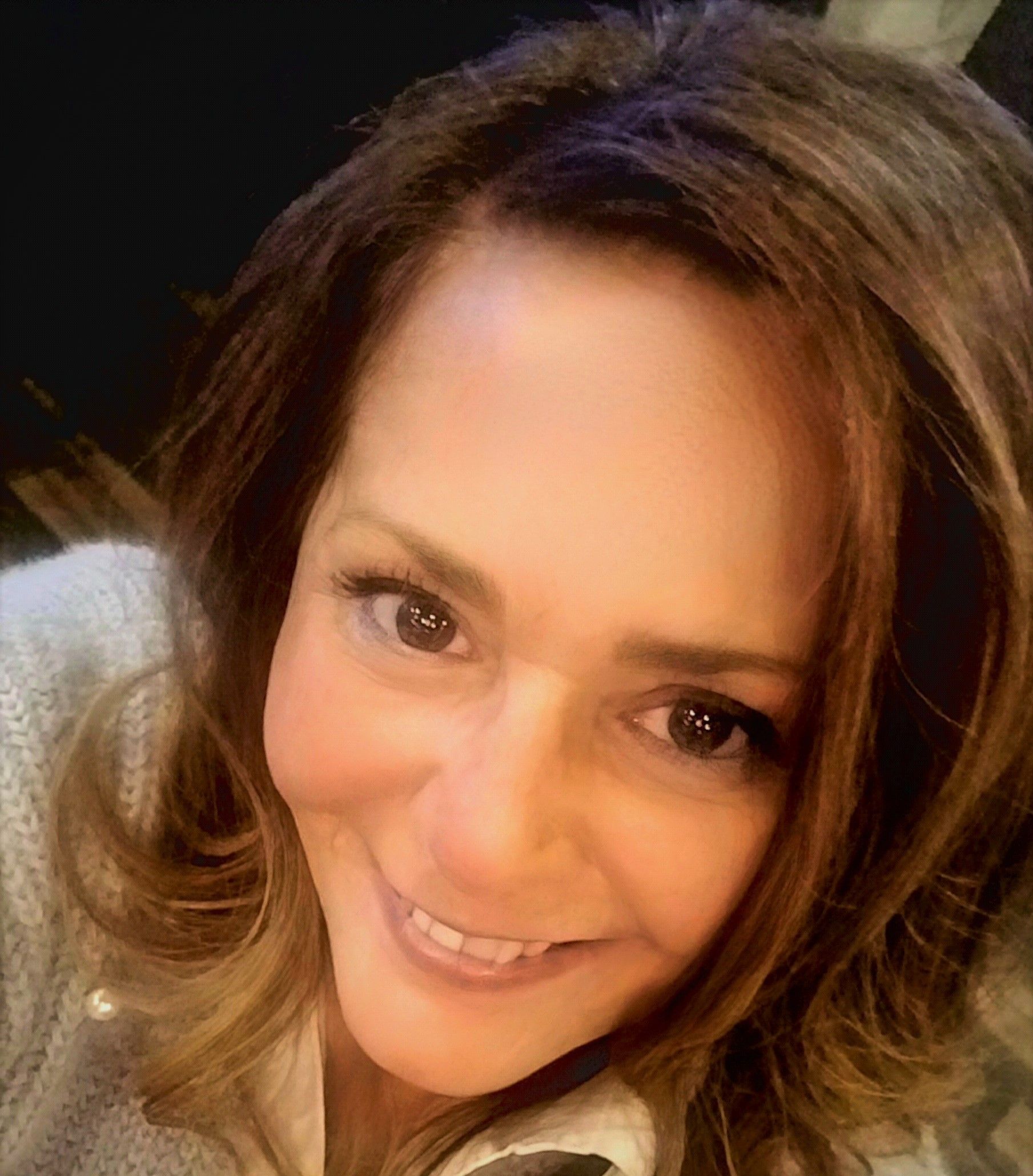 A close up of a woman 's face with a smile on her face.