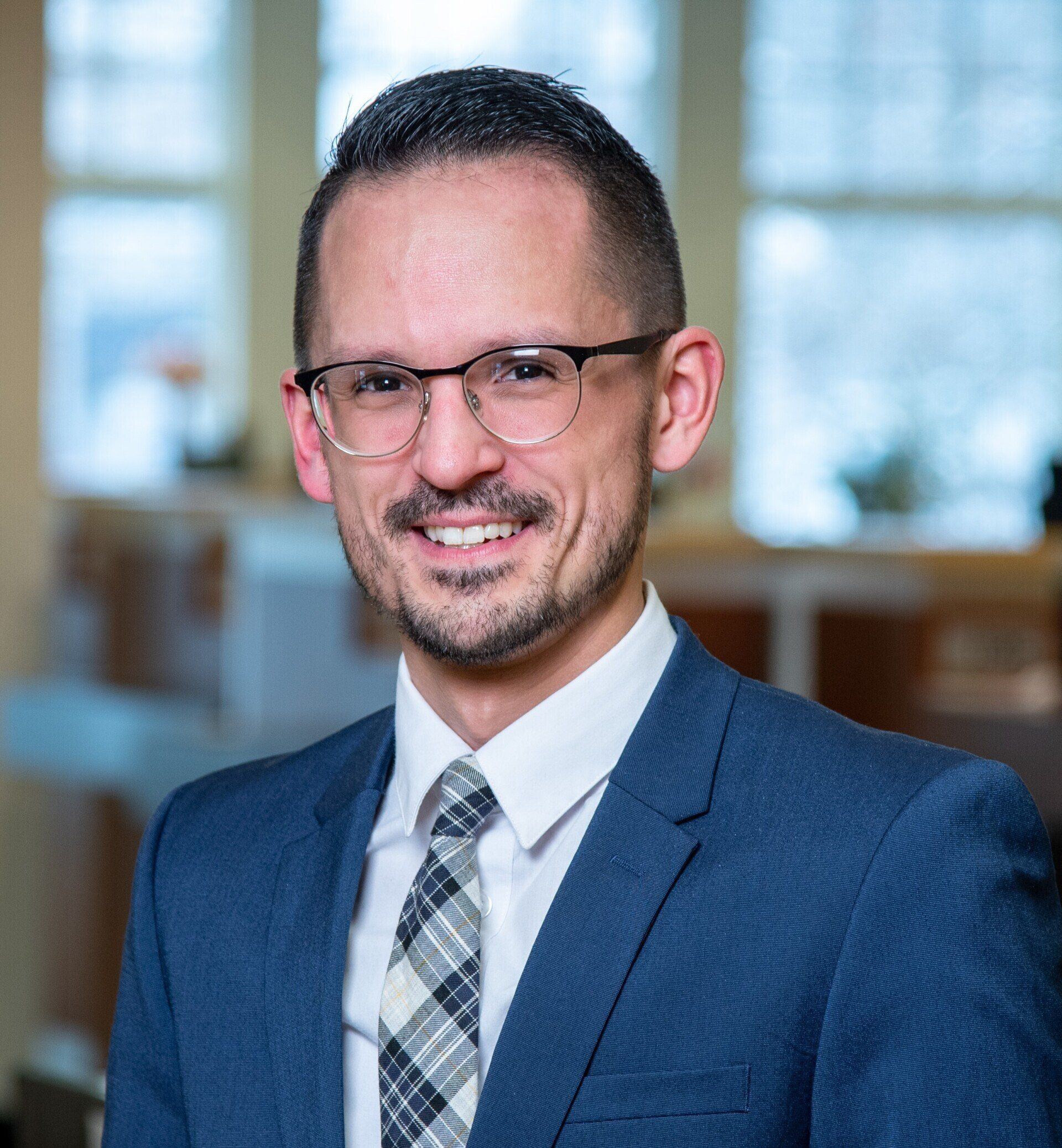 A man in a suit and tie is smiling for the camera.
