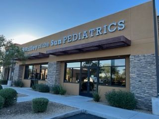 Valley of the Sun Pediatrics building with large windows, brown awning, and stone accents.