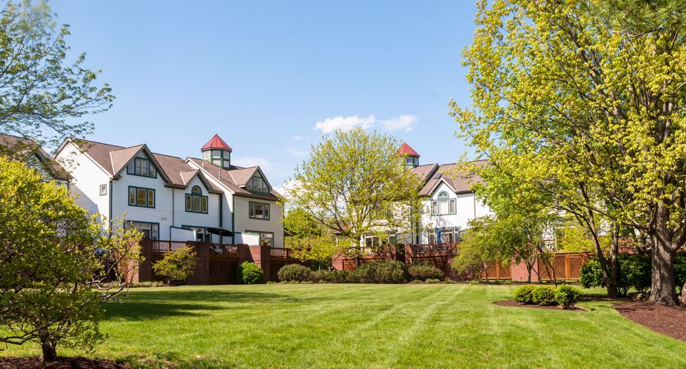 A row of houses with a large lawn in front of them.