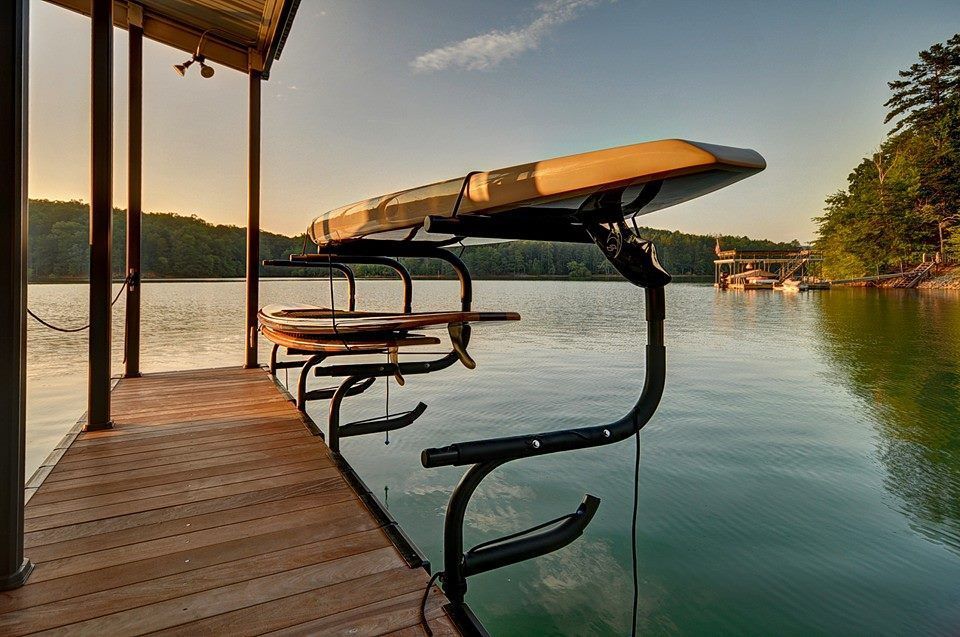 Covered dock with life rings and a canoe over calm lake water at sunset