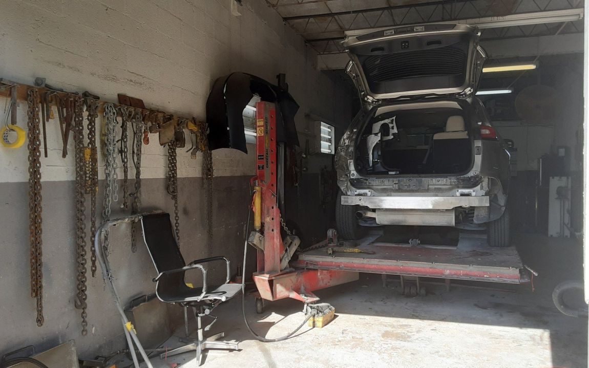A car is sitting on a lift in a garage.