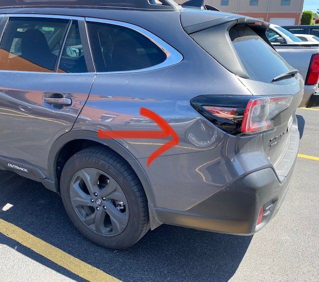 A gray car with a red arrow pointing to the left