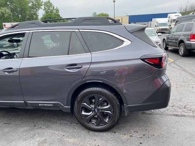 A gray subaru outback is parked in a parking lot.