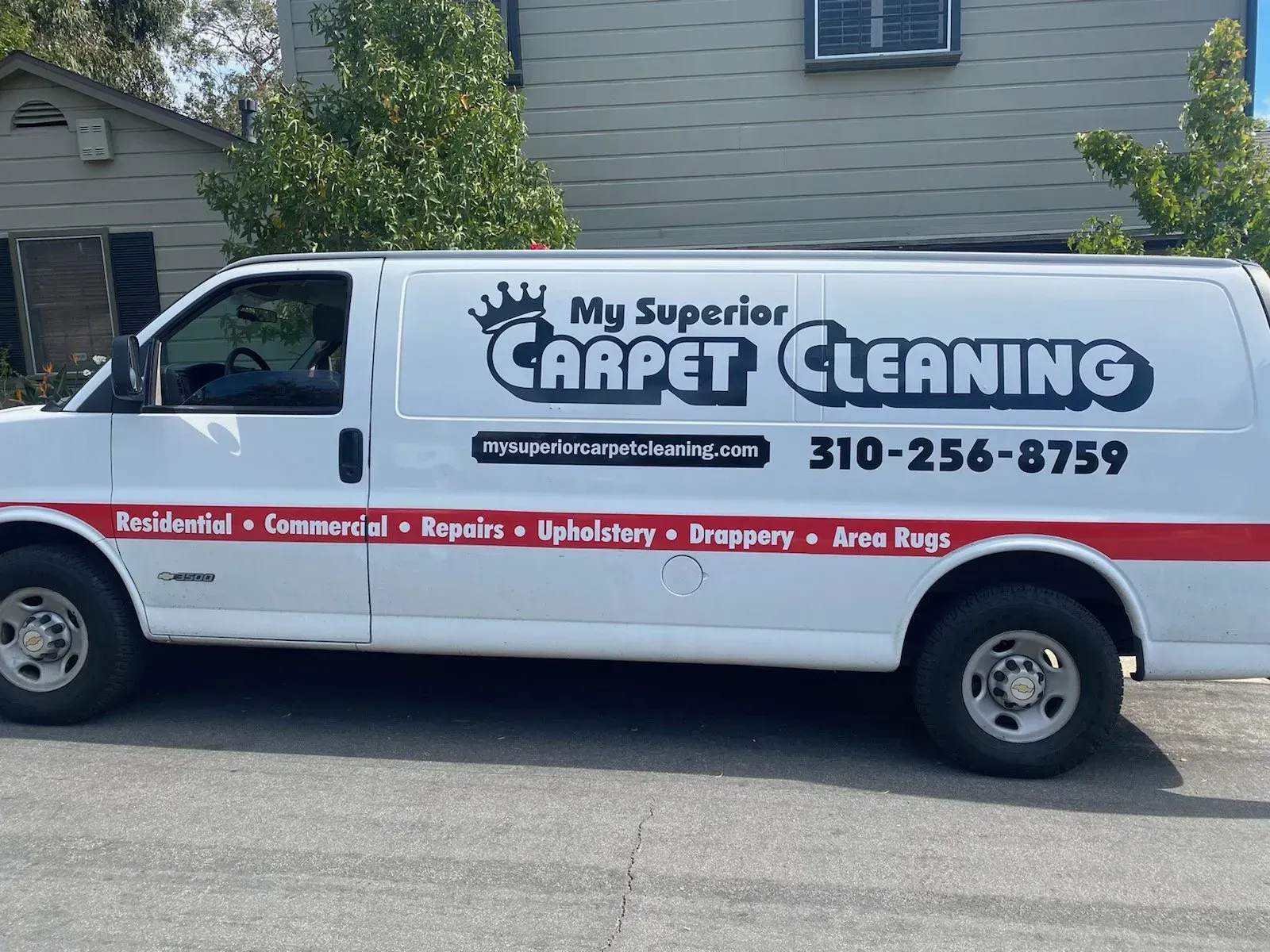 White My Success Carpet Cleaning van parked on a street, with company logo and phone number on the side.