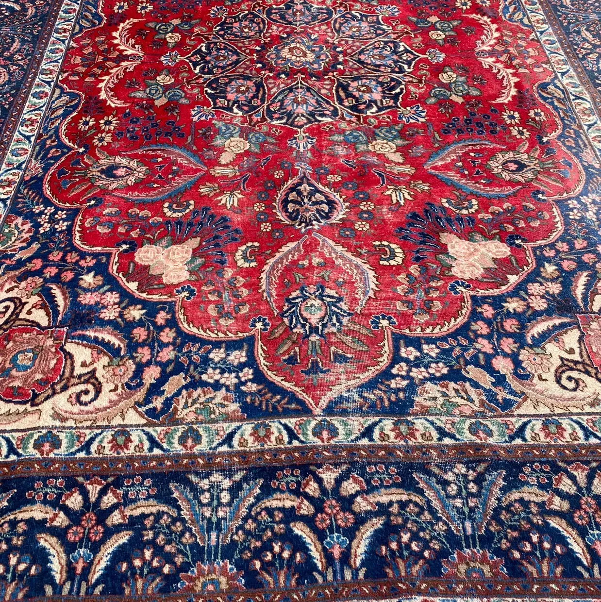 Ornate red, blue, and cream Persian-style rug with floral and medallion patterns