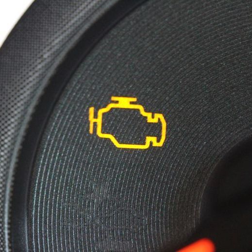 Yellow check engine warning light on a car dashboard display