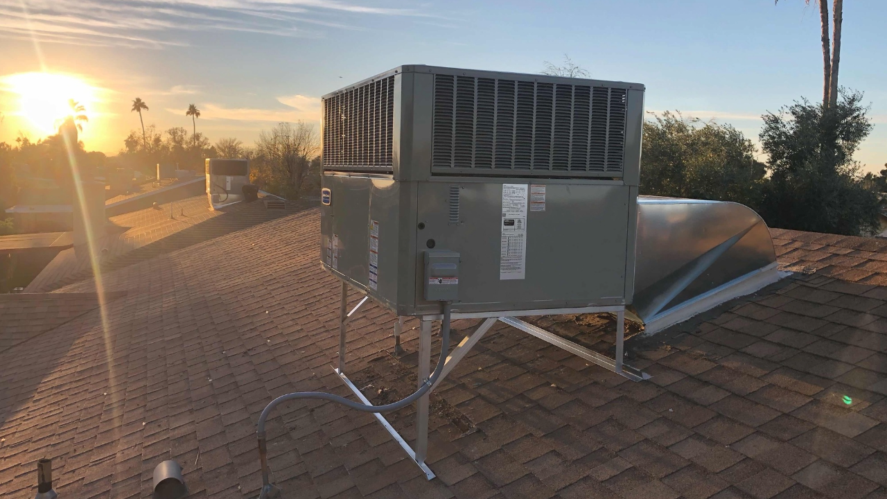 A large air conditioner is sitting on top of a roof.