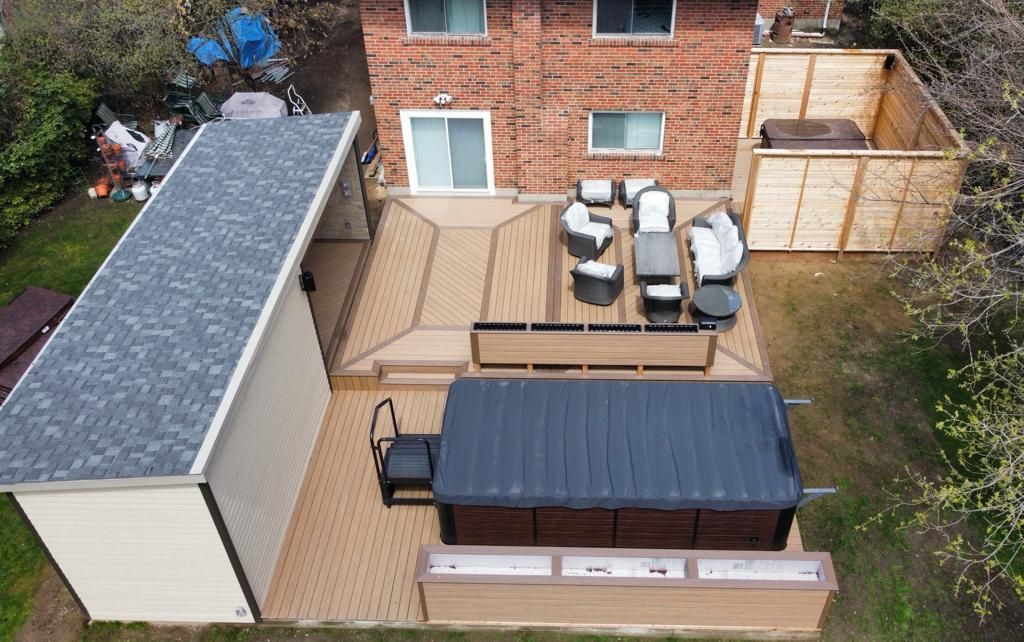 Backyard patio with hot tub, outdoor dining set, shed, and brick house wall
