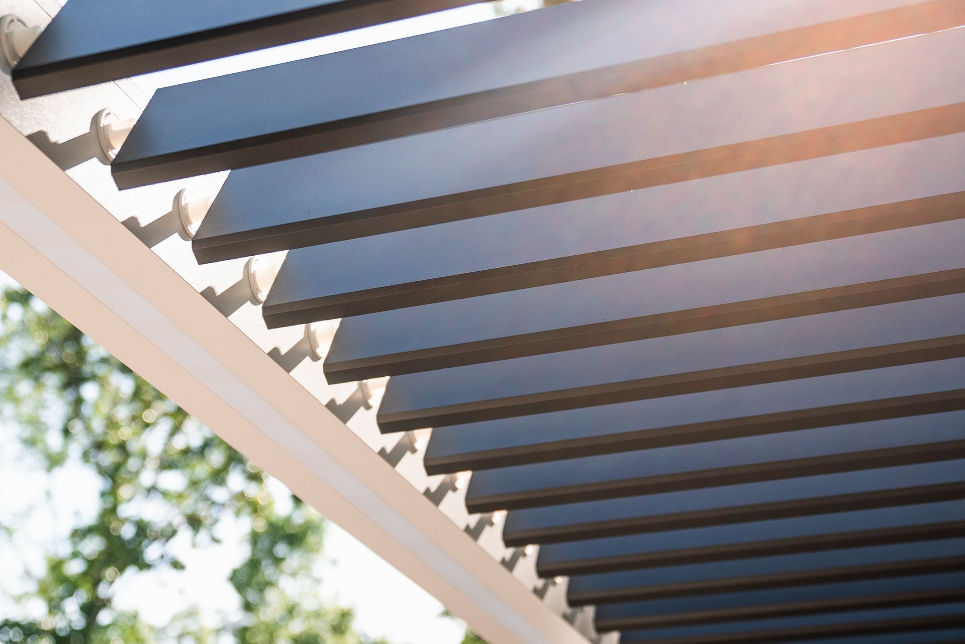 The sun is shining through the roof of a pergola.