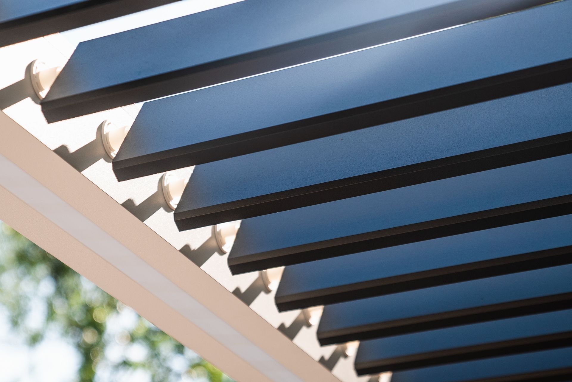 A close up of a pergola with the sun shining through the shutters.