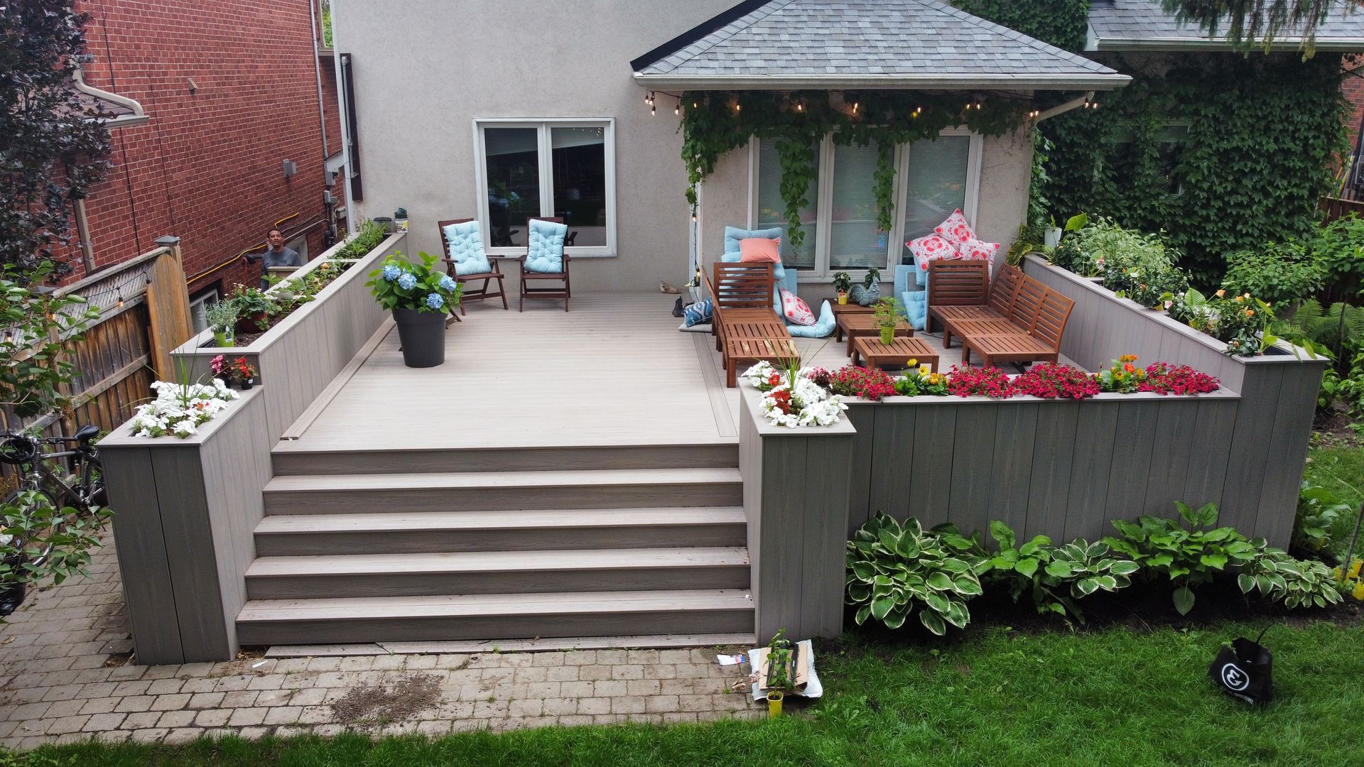 A backyard with a patio and stairs leading up to it.
