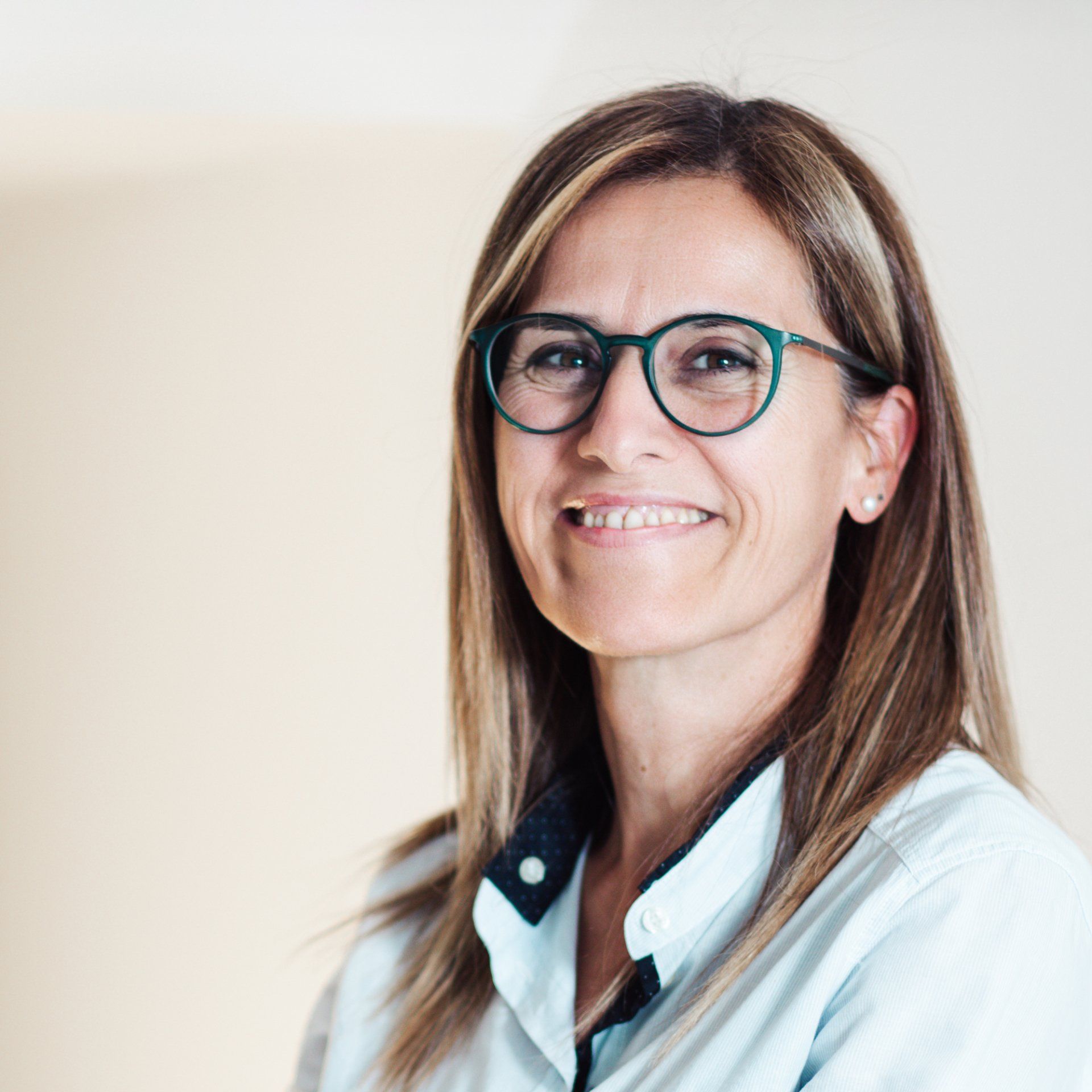 Una donna che indossa gli occhiali sorride alla telecamera