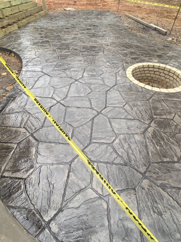 Gray concrete patio tiles with dark grout lines in a diagonal grid pattern