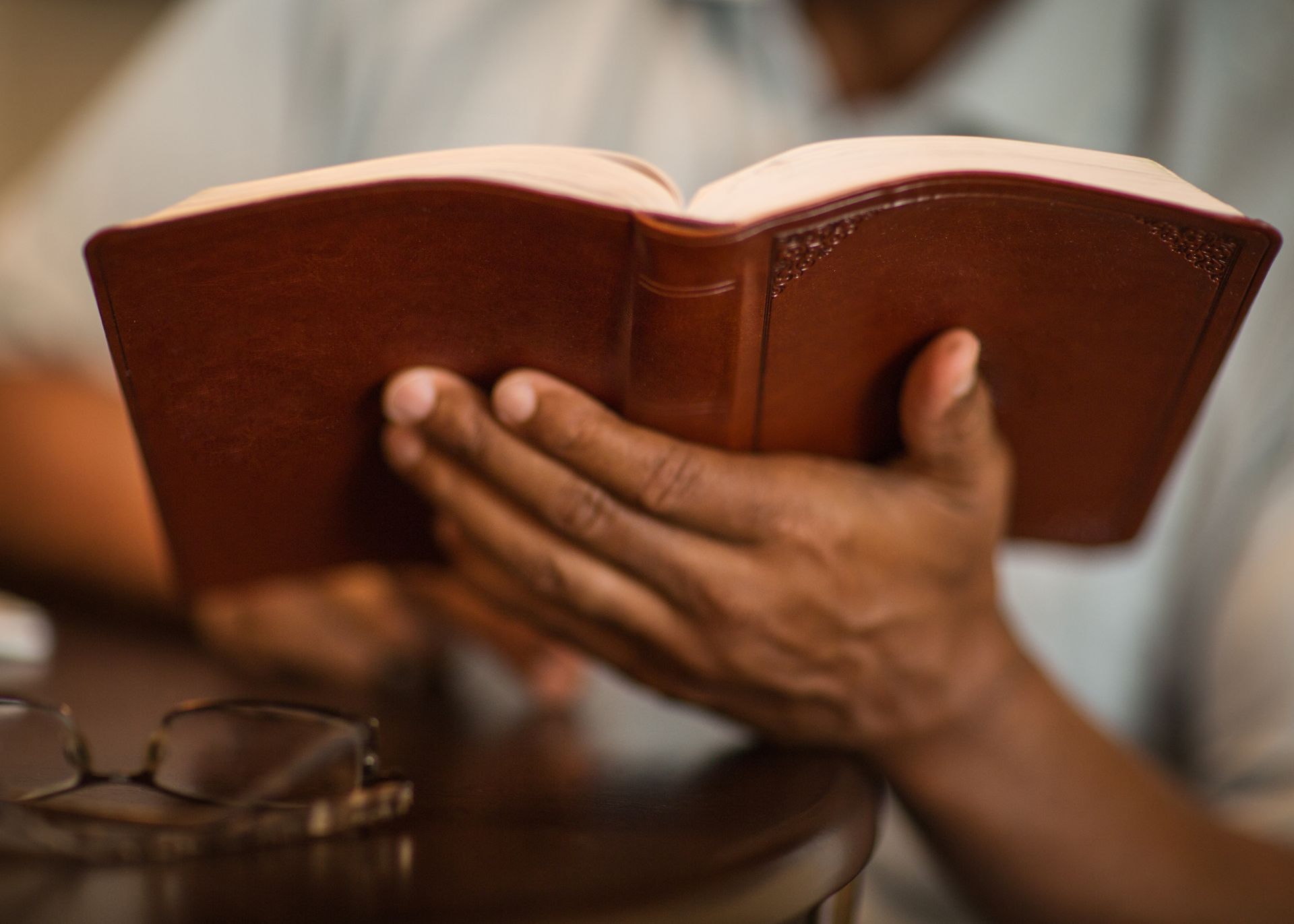 A man is holding an open bible in his hands.