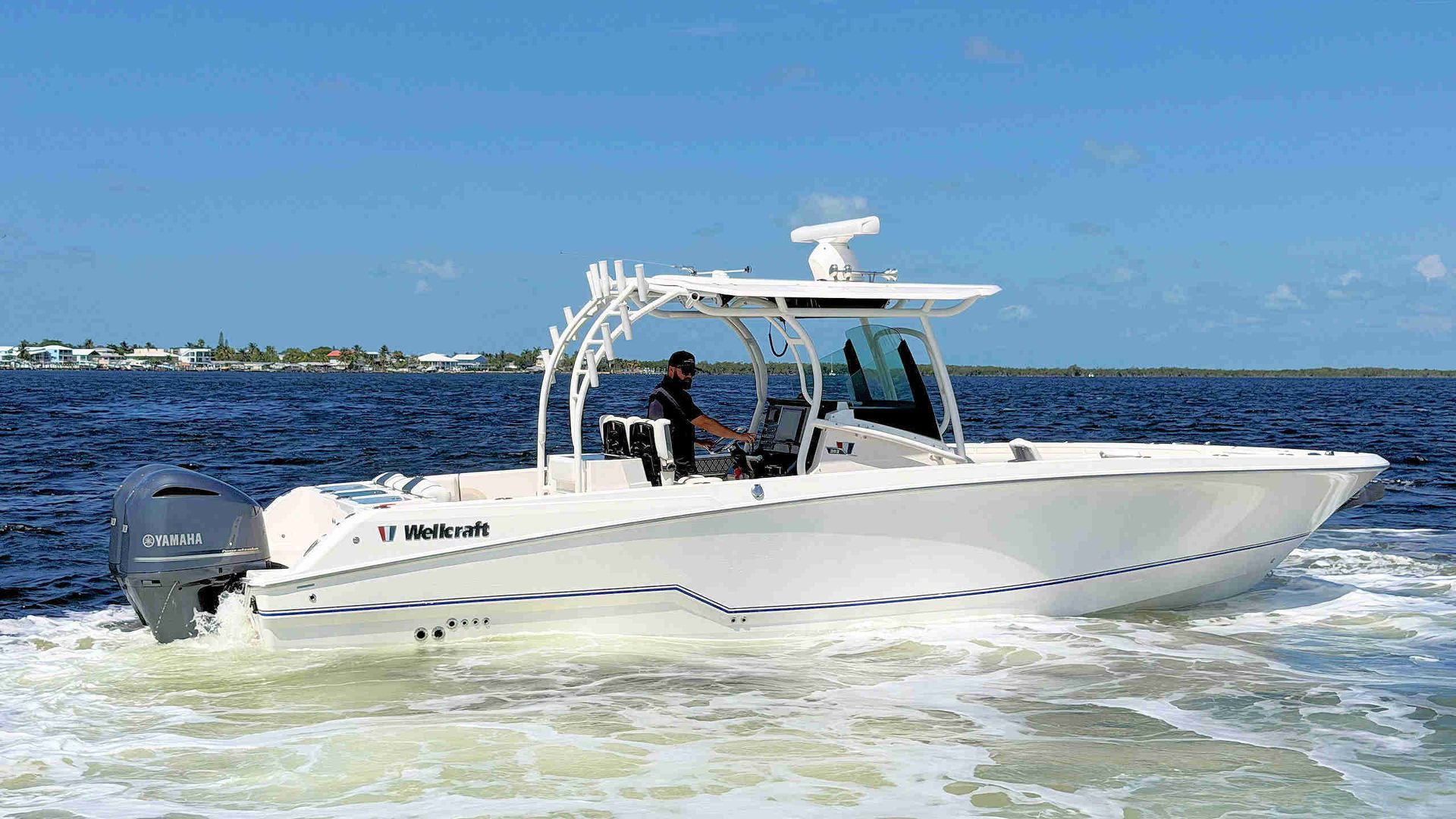 White center-console boat cruising on choppy blue water under a clear sky