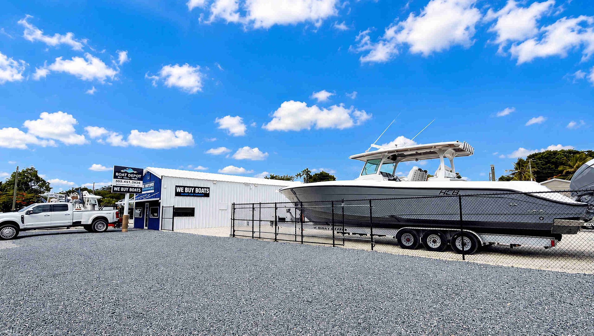 Main Boat Depot Dealership with new white tow truck and sales office in background and boat